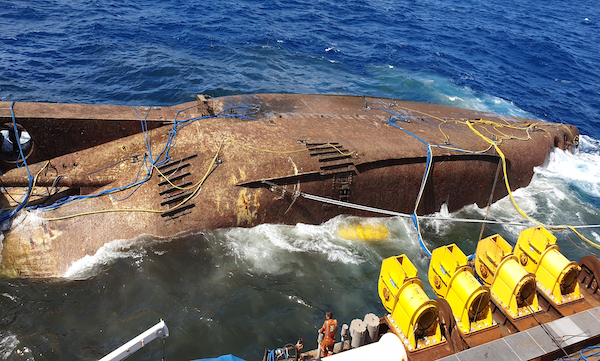 A ship being brought up from the water to be salvaged